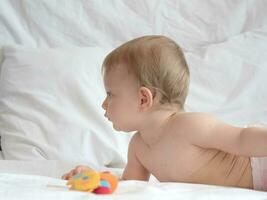 Baby lying and playing with toy photo