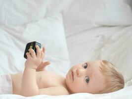 Blond blue eyes baby on the bed photo