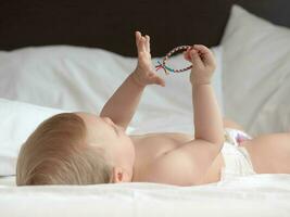 Baby lying on white bed photo