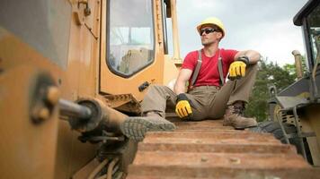 construction lourd devoir équipement ouvrier. bulldozer opérateur relaxant pendant le sien emploi. video