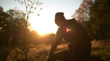 caucasico corridore con cuffie assunzione corto freno durante lungo tramonto correre. video