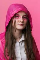 Portrait of informal young adult woman with pink stage make-up painted on face, looking at camera photo