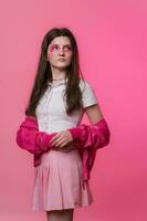 Hipster female with pink stage make-up painted on face, dressed in pink jacket, skirt, white t-shirt photo