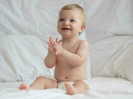 Cute Baby Sitting and Smiling on The Bed photo