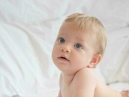 Portrait of cute blond baby lying photo