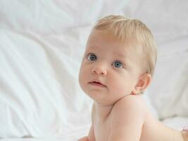 Portrait of cute blond baby lying photo