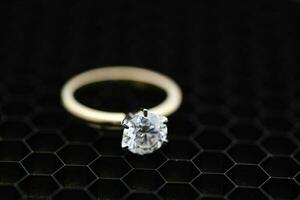 Solitaire Engagement Diamond Ring on Black Grid Background photo