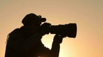 naturaleza fotógrafo tomando imágenes a el puesta de sol. panorámico foto. lento movimiento imágenes video