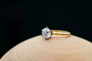 Gold Engagement Diamond Ring on Wooden Background photo