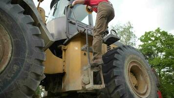 caucasien bulldozer opérateur dans le sien 30s en train de préparer pour le sien emploi. construction industrie thème. video