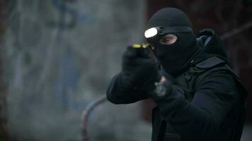 especial policía efectivo. hombres vistiendo táctico Oeste y negro máscara con arma de fuego en mano. ilegal actividad aplicación. video