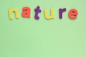 Colored letters Nature on green background. World Earth Day concept. Ecology green planet card. Environmental conversation and protection. Social banner, poster photo