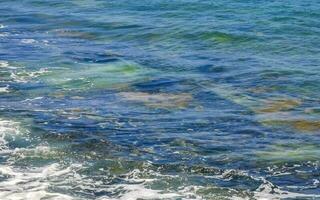 Stones rocks corals turquoise green blue water on beach Mexico. photo