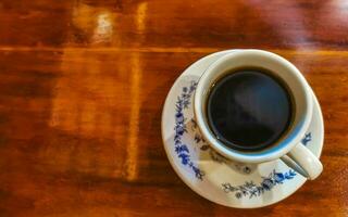 Blue white cup pot with black coffee wooden table Mexico. photo