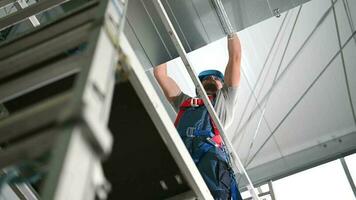 air conditionnement technicien en portant métal pièces et installation ventilation arbre unité sur plafond de Nouveau construction placer. video