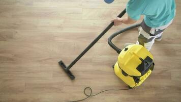 caucásico hombres Pasar la aspiradora Departamento nuevo madera dura piso. hogar limpieza tiempo. video