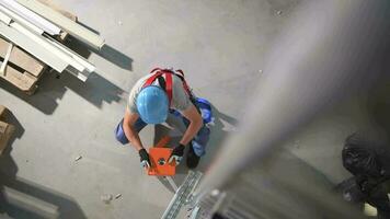 Male Contractor Adding Two Counter Weights To Scaffolding At Indoor Construction Site. video