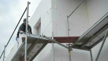 Worker Moving Insulation Blocks on a Scaffolding video