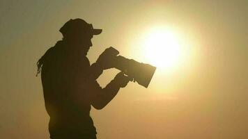 Extérieur photographe équipé avec grand téléobjectif lentille dans le éloigné emplacement pendant scénique le coucher du soleil. video