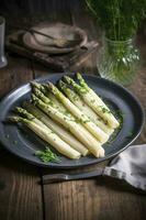 Modern style traditionally steamed white asparagus with butter sauce and cress served close-up on a Nordic design plate, generate ai photo