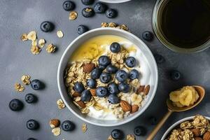 Bowl of greek yogurt with oatmeal granola, banana, blueberry, nuts, chia seeds and honey on gray table. Top view, generate ai photo