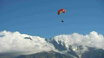 Paraglider Above Snowy Mountain Peaks Enjoying His Flight video