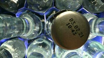 View Of Clear Glass Bottles Filled With Water And Metal Caps With Expiration Date Organized In Plastic Container. Person Choosing And Grabbing One Of Bottles. video