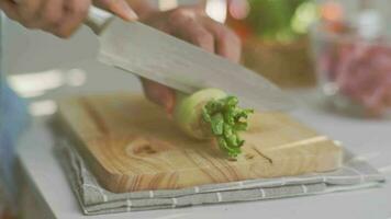 cucinando - dello chef mano taglio bianca ravanello su un' chopping tavola nel il cucina. video