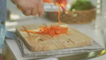 Kochen Koch Hände sind Peeling Möhren im das Küche. video