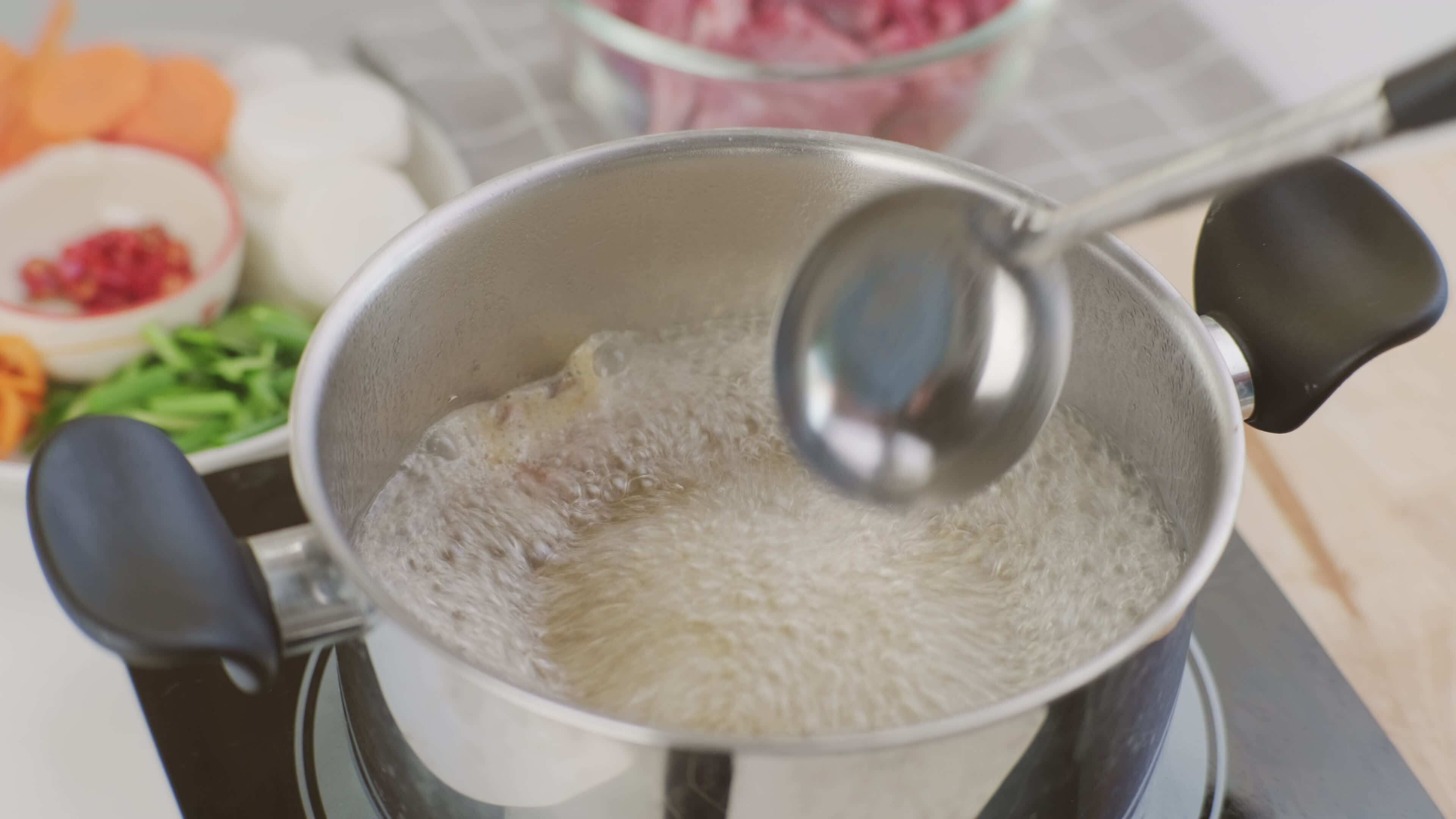Cooking Chef's hands are putting pork ribs in a pot of boiling water in