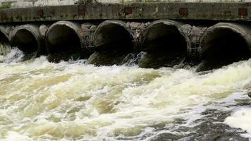 ambientale inquinamento, ambientale disastro. scarico di inquinata liquame in il fiume a partire dal fabbrica calcestruzzo tubi. pericoloso rifiuto acqua. ambientale protezione. acqua inquinamento. video