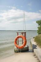 Marine lifebuoy on fence on water surface, generate ai photo