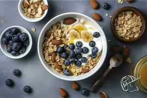 Bowl of greek yogurt with oatmeal granola, banana, blueberry, nuts, chia seeds and honey on gray table. Top view, generate ai photo