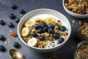 Bowl of greek yogurt with oatmeal granola, banana, blueberry, nuts, chia seeds and honey on gray table. Top view, generate ai photo
