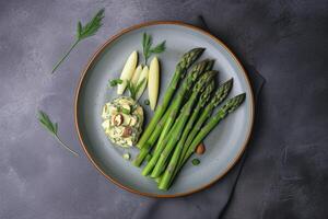 Traditionally grilled green asparagus with herbs as a top view on a modern design plate with copy space, photo