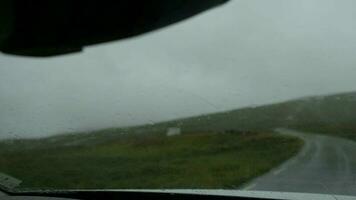 carro parabrisa limpadores lento movimento imagens de vídeo. região selvagem escandinavo estrada e a chuvoso clima. video