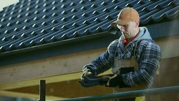 Kaukasisch dakbedekking arbeider in zijn Jaren 30 met keramisch dak tegels in handen voorbereidingen treffen voor werk. video