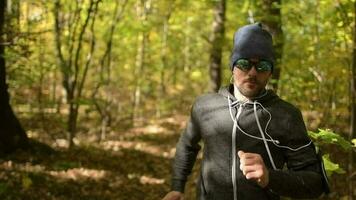 uomini nel il suo 30s jogging nel un' foresta durante autunno stagione. video