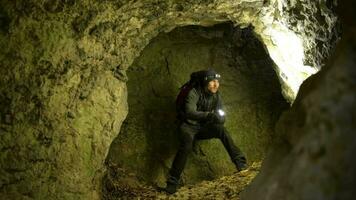 salvador con Linterna mirando alrededor en el profundo cueva. rescate misión. video