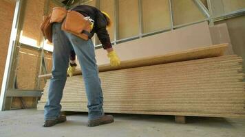 Worker Moving Plywood Boards. Construction Site. video