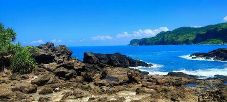 Menganti Beach which looks beautiful with rocks, is located in the city of Kebumen, Java Island, Indonesia photo