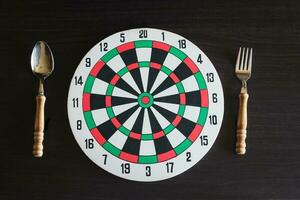 Dart board with spoon and folk on backround. photo