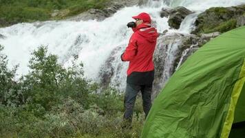 Überleben Expedition in das Wildnis. szenisch Camping Stelle mit Wasserfall. schleppend Bewegung Aufnahmen video