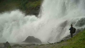 caucásico turista con mochila en frente de el grande cascada. Noruega, Europa. video