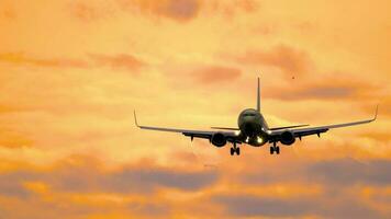 Airplane silhouette landing at the airport during sunset. Tourism and travel concept video