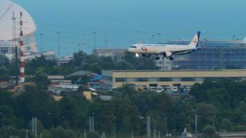 SOCHI, RUSSIA AUGUST 02, 2022 - Plane Ural Airlines decline before landing on the background of the infrastructure of the city, side view. Tourism and travel concept video