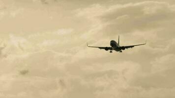 Airplane descending for landing, background of illuminated dark clouds. Release Chassis. Tourism and travel concept video