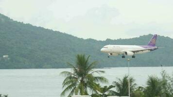 Phuket, Thaïlande décembre 02, 2016 - Airbus a320 de thaïlandais voies aériennes atterrissage à phuket aéroport, longue coup côté vue video