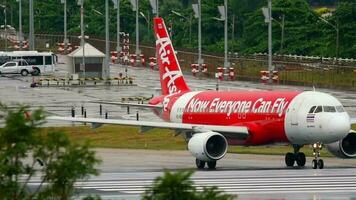 PHUKET, THAILAND DECEMBER 02, 2016 - Airbus A320 AirAsia on runway before takeoff at Phuket Airport. Rainy day, wet airfield. Tourism and travel concept video