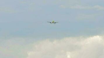 Passenger plane with green livery approaching to land in a cloudy sky, front view video